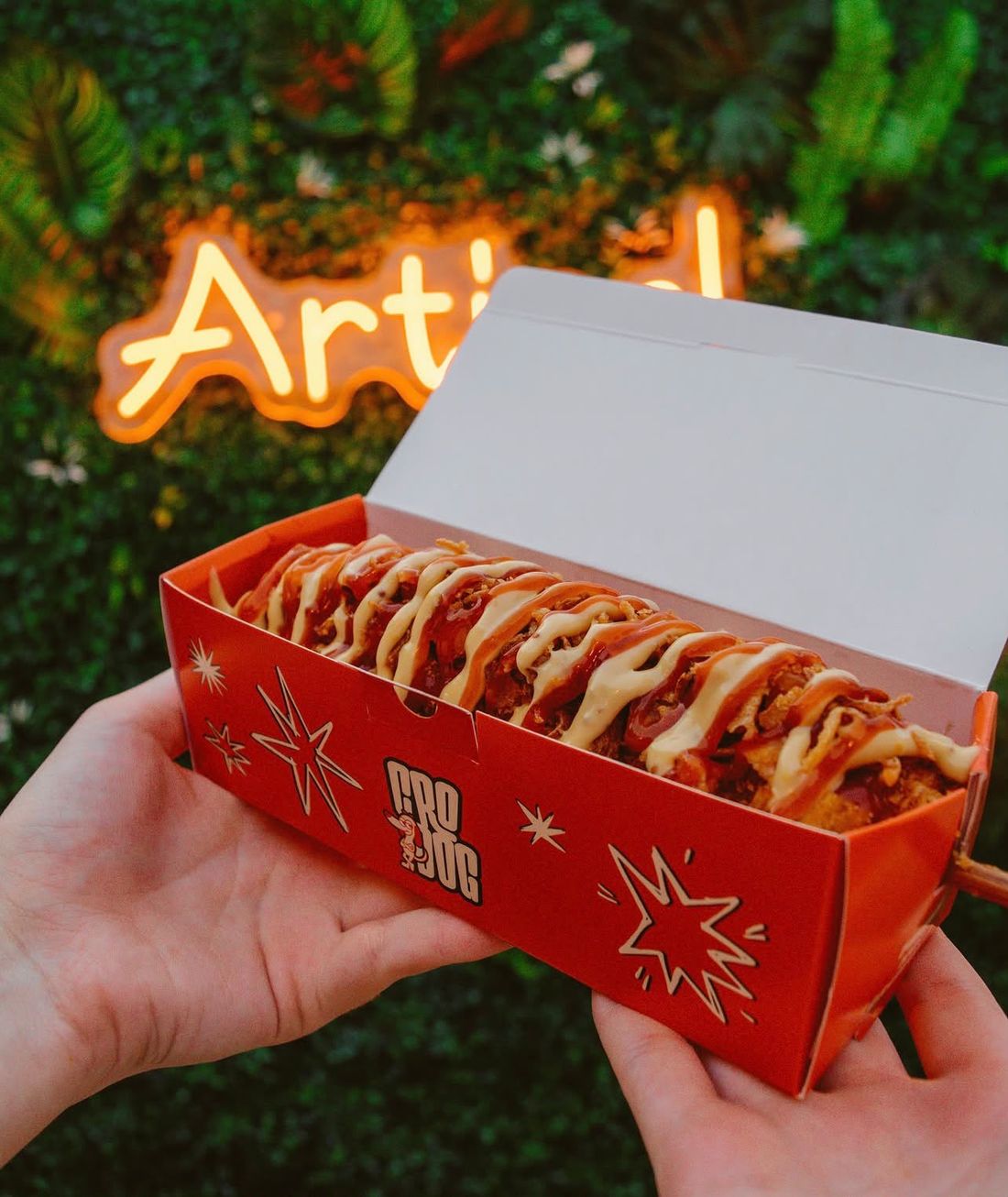 CroDog corn dog s umacima i prženim lukom u narančastoj CroDog kutiji